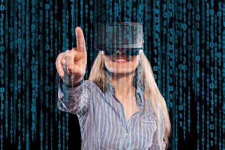 Pretty woman in grey shirt touching something curiously using the virtual reality headset on black...