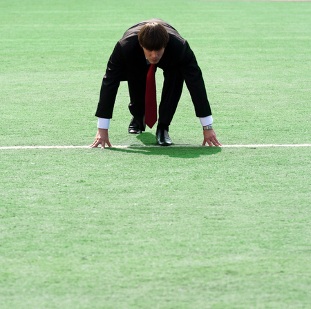 young man in black suit ready to runの写真素材