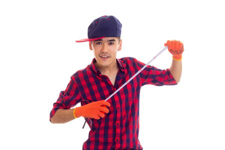 Young man in gloves and snapback holding tape-measureの写真素材