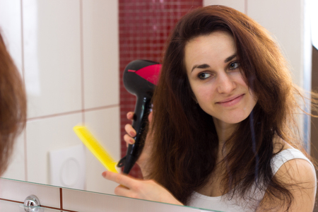 Young woman drying her hair in bathroomの写真素材