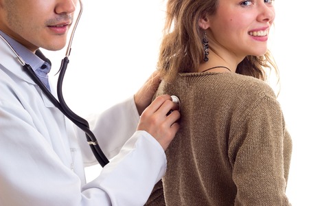 Doctor listening to womans backの写真素材