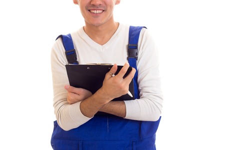 Young man in blue overall holding pen and folder