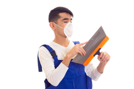 Man in blue overall with respirator holding spatulaの写真素材