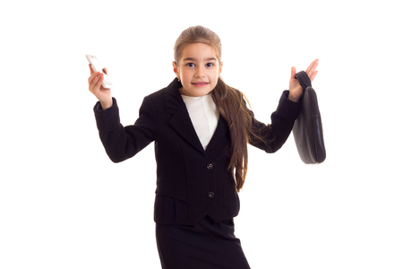 Little girl in black jacket holding diploma and smartphoneの写真素材