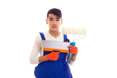 Man in blue overall with gloves holding spatula and roll