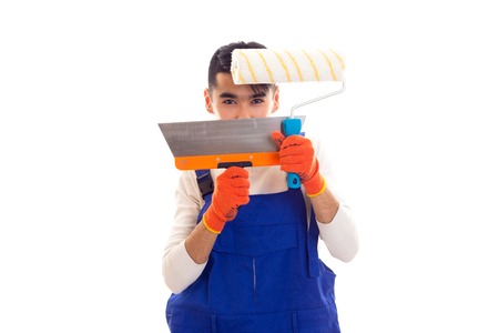 Man in blue overall with gloves holding spatula and rollの写真素材