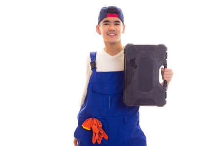 Young man in overall holding toolbox