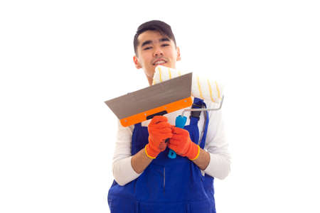 Man in blue overall with gloves holding spatula and rollの写真素材