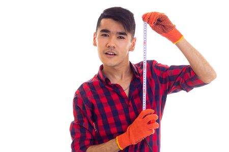 Young man in gloves holding tape-measureの写真素材