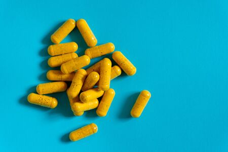 Yellow healthy harmaceutical medicine pills or vitamins in capsulesの写真素材