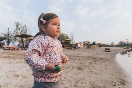 Little cute girl looking on sunset on the beachの写真素材
