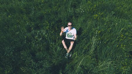 Top view aerial photo of freelancer man on the grass with laptopの写真素材