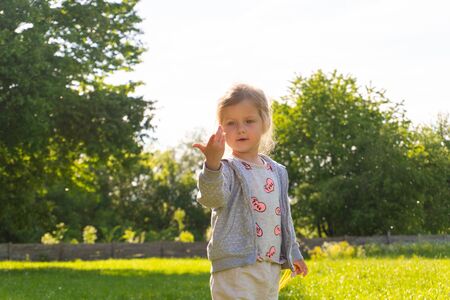 Little girl playing with fure from trees in the park