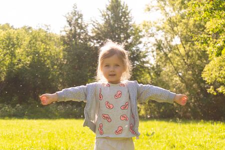 Little kid girl enjoy summer sunny day in the park