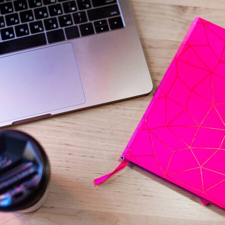 Top view on laptop and pink notebookの写真素材