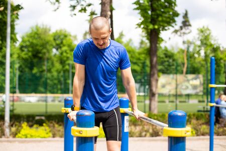 Man doing bars push up workout in the park