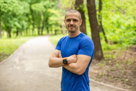 Sporty man with crossed hands dressed in blue t-shirtの写真素材