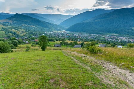 Rural view on valley with small viallage and big mountains