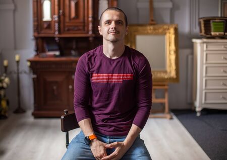 Portrait of man sitting at home in modern interiourの写真素材