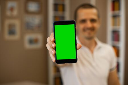 Man holding cellphone with chromakey green screenの写真素材