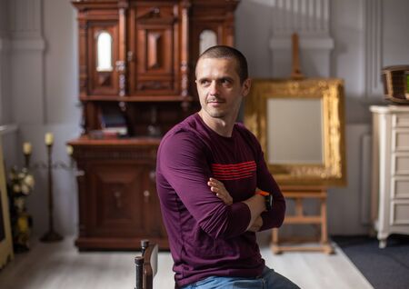 Man looking away sitting in modern art interiourの写真素材