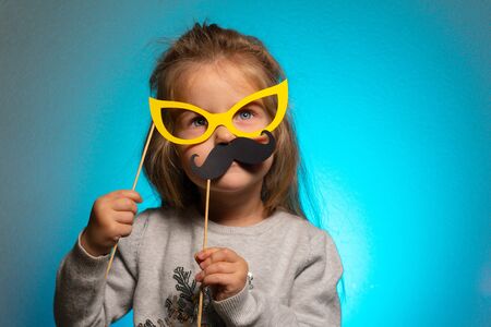 Little funny girl with mustaches and paper glassesの写真素材