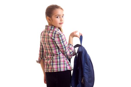 Little girl standing back to camera and holding schoolbag in handの写真素材
