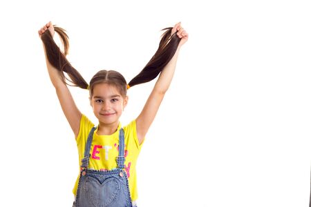 Happy funny little girl with hairs up at white backgroundの写真素材