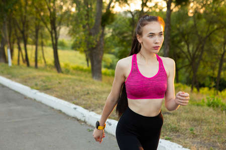 Young woman runner training in summer parkの写真素材