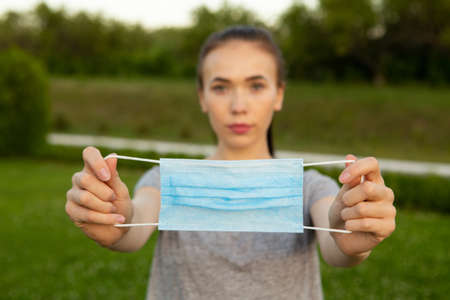 Closeup view on medical blue mask in hands of woman.の写真素材