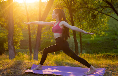 Woman is doing exercise on beautiful nature in the backgroundの写真素材