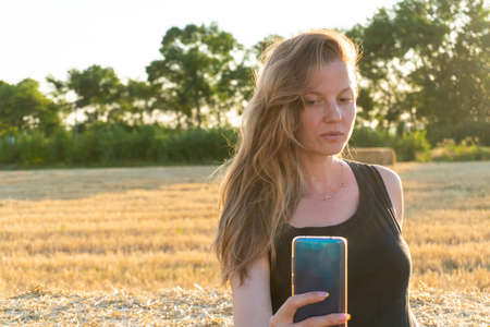 Woman in black long dress looking making selfie