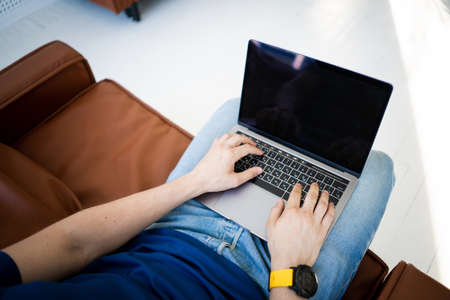 Man freelancer working on laptop sitting in chairの写真素材