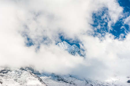 Fresh snow on the top of Mount Kangtega peak hidden in clouds. Trekking in Nepal Himalayas. EBC (Everest base camp trek) trail upper part from Lukla to EBC of Everest trek. Nepal.の写真素材