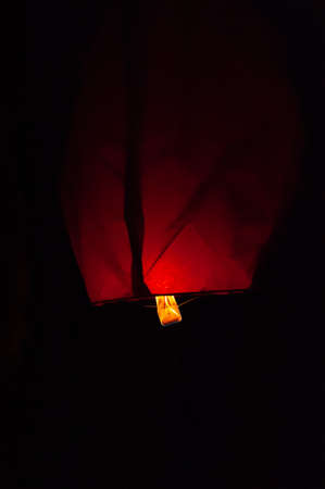 Detail of launching sky lantern. Close up ignite flying lantern, floating lantern. Fire and hot-air balloons on dark night sky. Lighting up.の写真素材