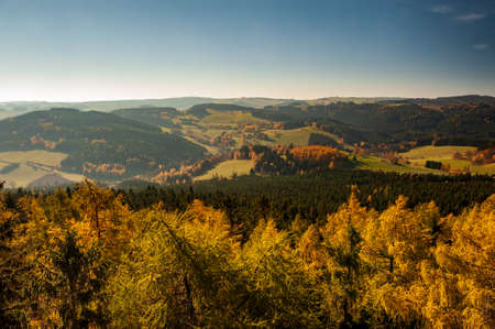 Sunset over autumn forest, fields and meadow in backlight. Evening sunbeams on meadow. Warm sun light in countryside of Bohemian Moravina Highlands, Å½ÄÃ¡r Hills, Vysocina, Czech Republic.の写真素材