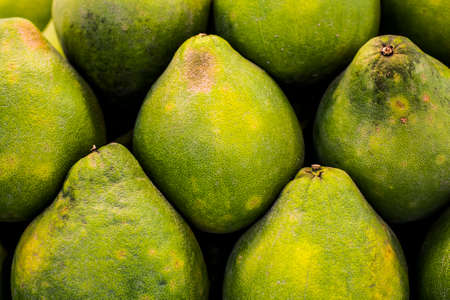 Imperfect pomelos stacked in a pile