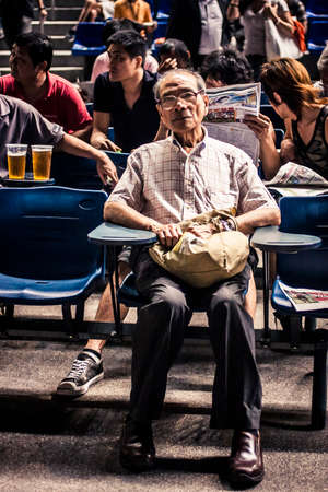 Hong Kong, China - 3 June, 2009: Man watching a horse race at the Happy Valley Racecourse in Hong Kongのeditorial素材