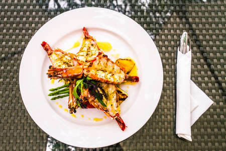 Black pepper tiger prawns on a white plateの写真素材
