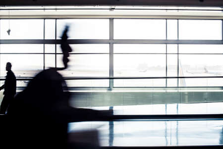 Passengers hurry towards a flight at a modern airportの写真素材
