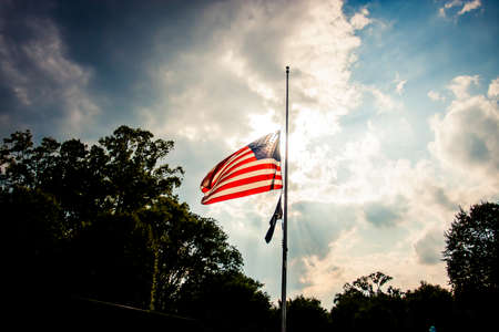 American flag at half mast on a holidayの写真素材