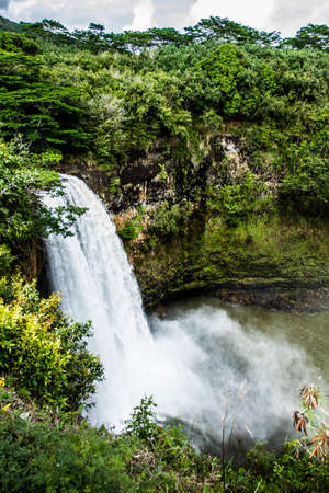 Waterfall surrounded by lush green jungleの写真素材