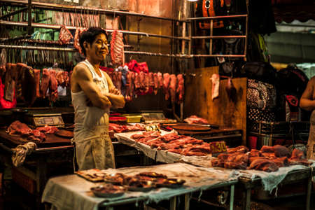 Hong Kong, China - 7 July, 2013: Butchers wait for customers at Chun Yeung Street Market in North Point Districtのeditorial素材