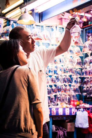 Hong Kong, China - 24 May, 2009: Middle age couple looking at a bag with exotic fish on Tung Choi Street in Mongkokのeditorial素材