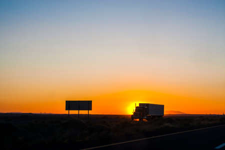 Semi-truck driving on an interstate at sunsetの写真素材