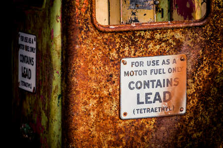 Abandoned gas pump with a rust and signsの写真素材