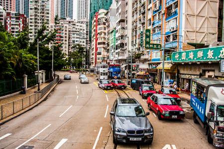 Hong Kong, China - 3 June, 2009: Taxis, cars and a double deck tram on Hennesy Road in Causeway Bay district during the daytimeのeditorial素材