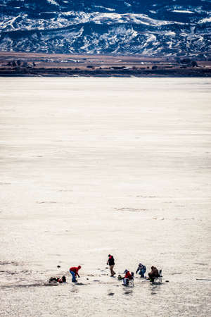 Ice fishing on a frozen reservoir in Wyomingの写真素材