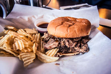 Pulled pork sandwich with a side of chipsの写真素材