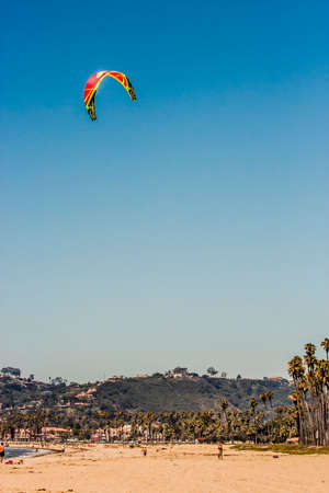 Santa Barbara, California - 8 August, 2008: Man with a parasail catching some wind on a clear and sunny day at the beachのeditorial素材